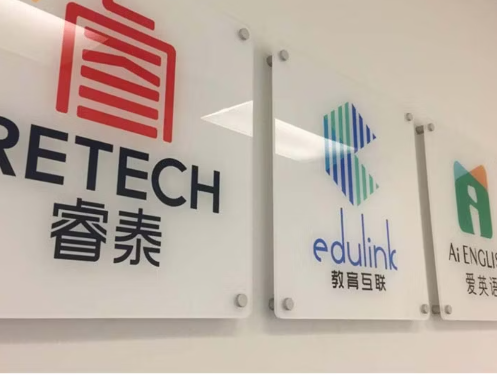 Clear acrylic board signage mounted on white wall with standoff hardware